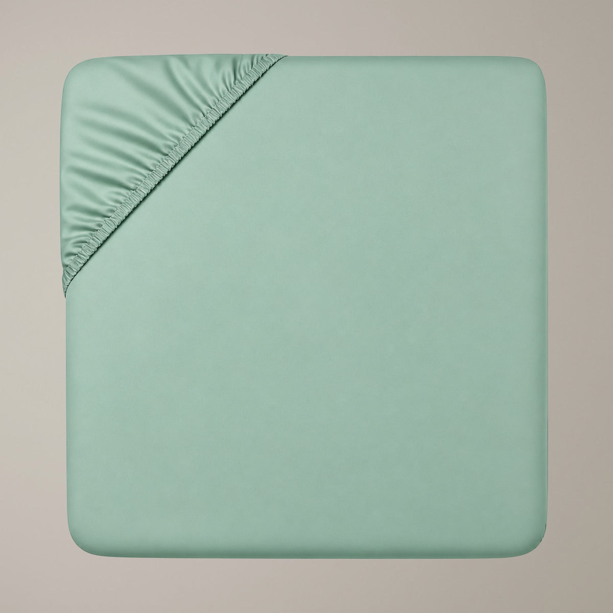 Eine Draufsicht auf ein salbeigrünes Finole Luxe Satin Spannbettlaken aus ägyptischer Baumwolle.