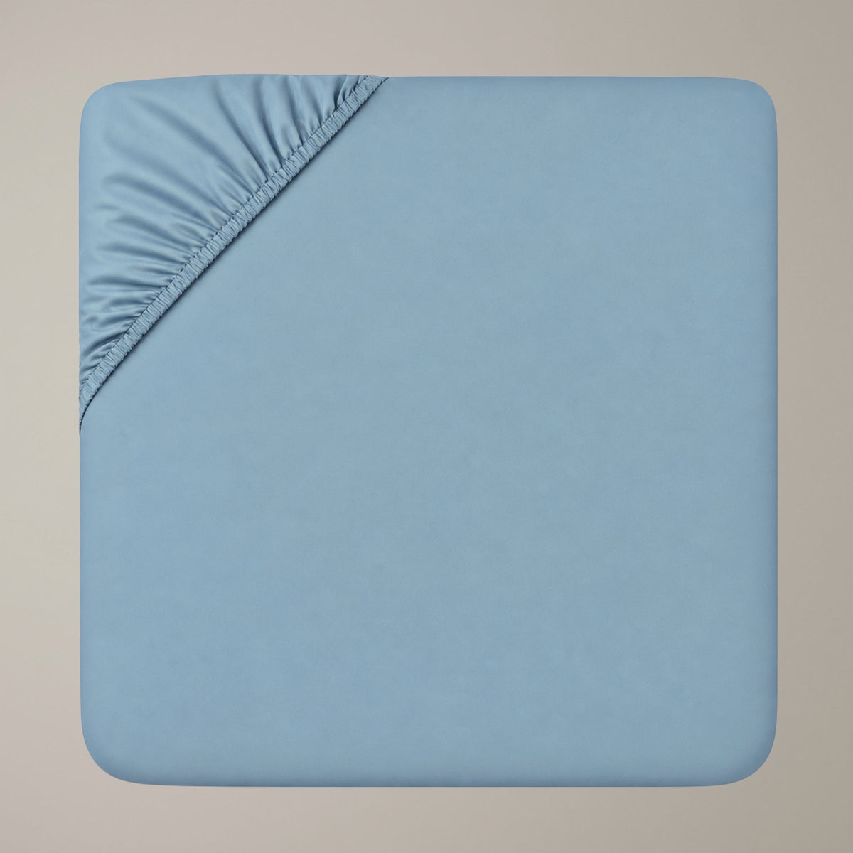 Draufsicht auf ein hellblaues Finole Luxe Satin-Spannbettlaken aus ägyptischer Baumwolle, wobei die elastischen Ecken besonders hervorgehoben sind.