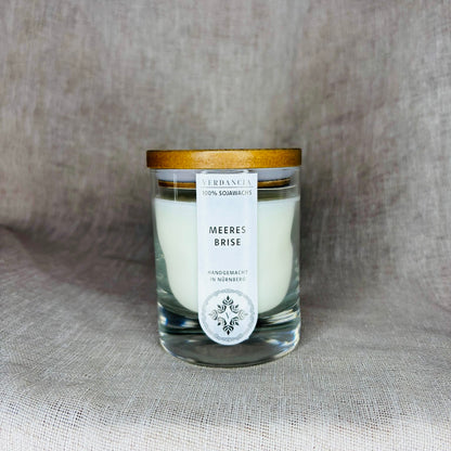 Duftkerze "Meeresbrise" von Verdancia mit Holz, Salbei und Meersalz, brennend in elegantem Glasbehälter.
