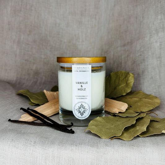 Soja Duftkerze von Verdancia in Vanille & Holz mit eleganter Verpackung und sanftem Lichtschein.