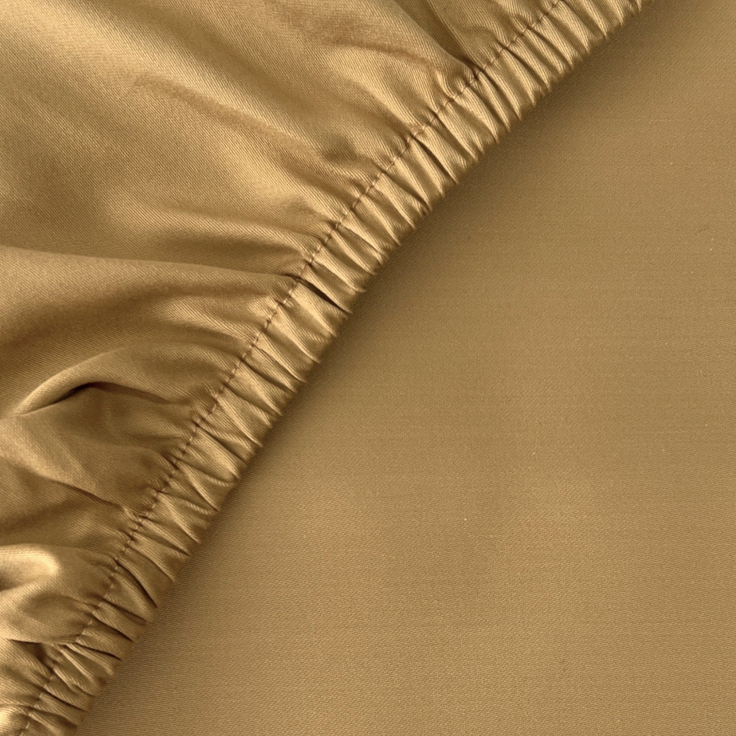 Feines Finole Satin Spannbettlaken aus 100% ägyptischer Baumwolle, seidig glatt und atmungsaktiv, auf einem Bett drapiert.