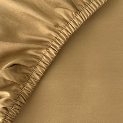 Feines Finole Satin Spannbettlaken aus 100% ägyptischer Baumwolle, seidig glatt und atmungsaktiv, auf einem Bett drapiert.