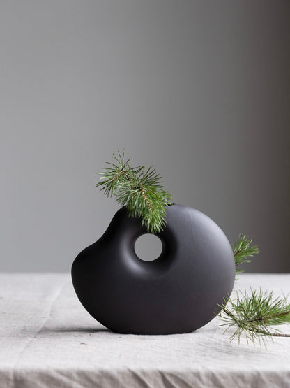 Dunkelgraue Keramikvase „Lunden“ von Storefactory, handgefertigt im Retro-Design, H19 cm, auf einem Tisch platziert