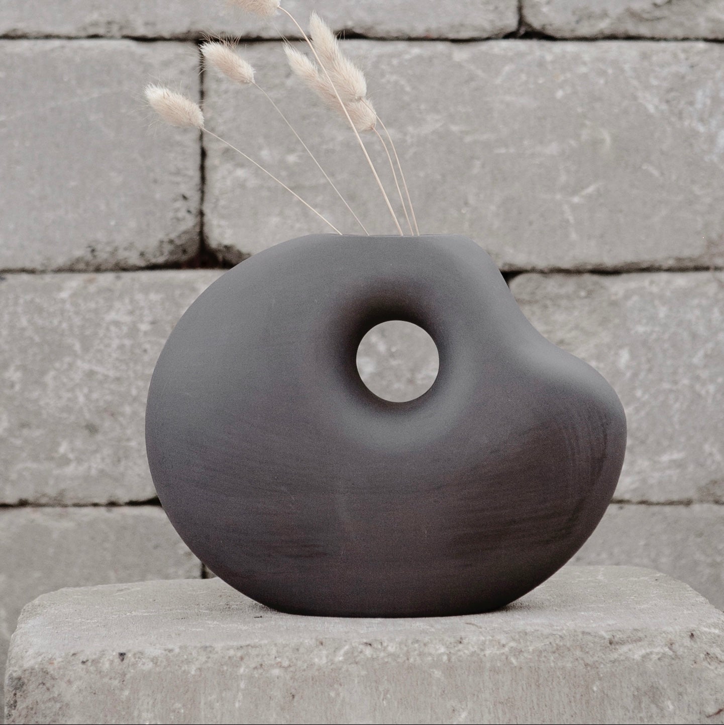 Dunkelgraue Keramikvase „Lunden“ von Storefactory, handgefertigt im Retro-Design, ca. 19 cm hoch.