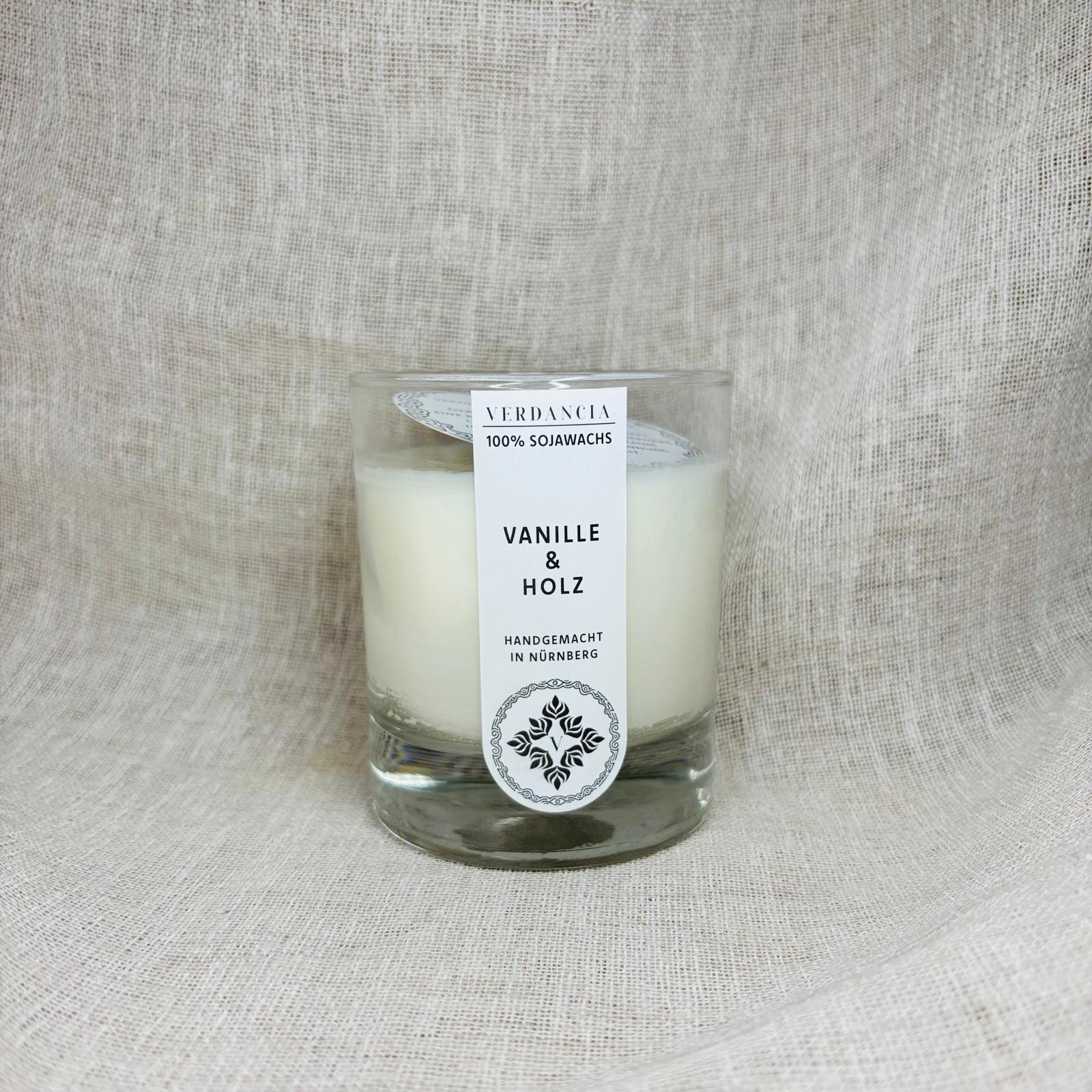 Verdancia Soja Duftkerze in Vanille & Holz, showcasing a sleek design and warm glow in a cozy setting.