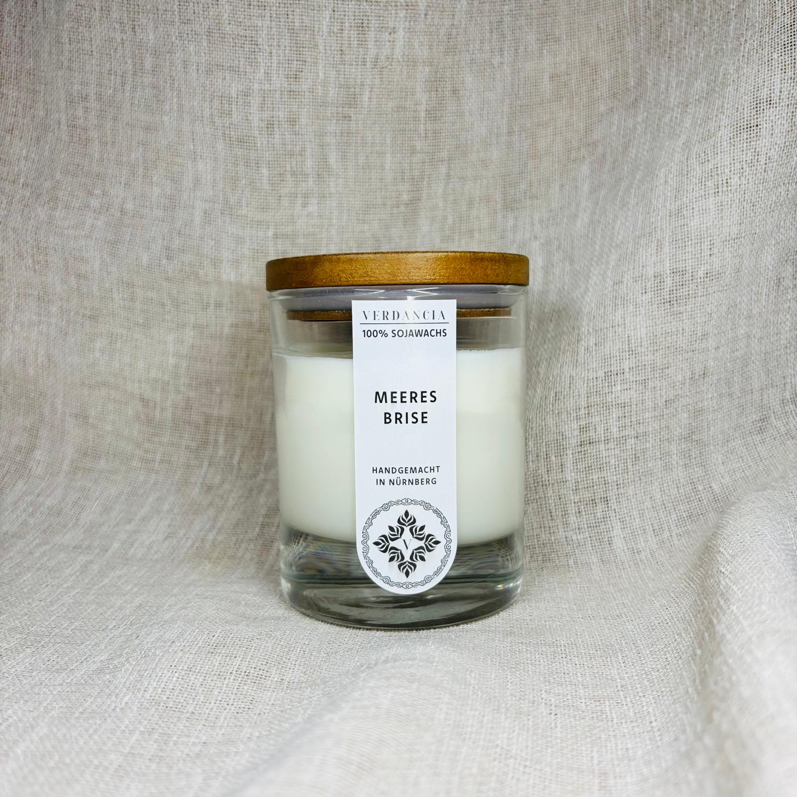 Duftkerze "Meeresbrise" von Verdancia mit Holz, Salbei und Meersalz, zeigt brennende Sojakerze in einem eleganten Glas.